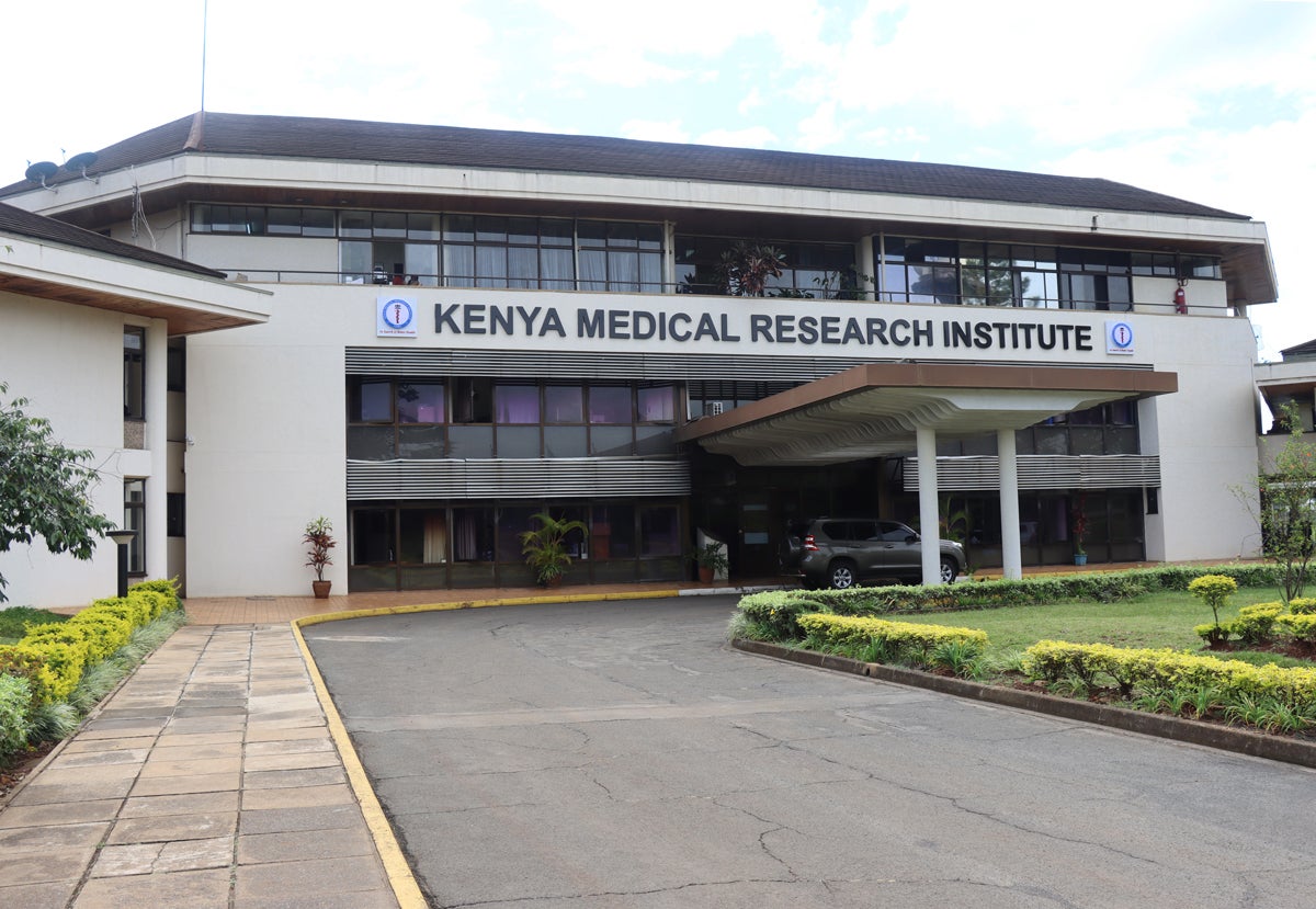Exterior of a two story white stucco building with the words "Kenyan Medical Research Institute" enscribed. 