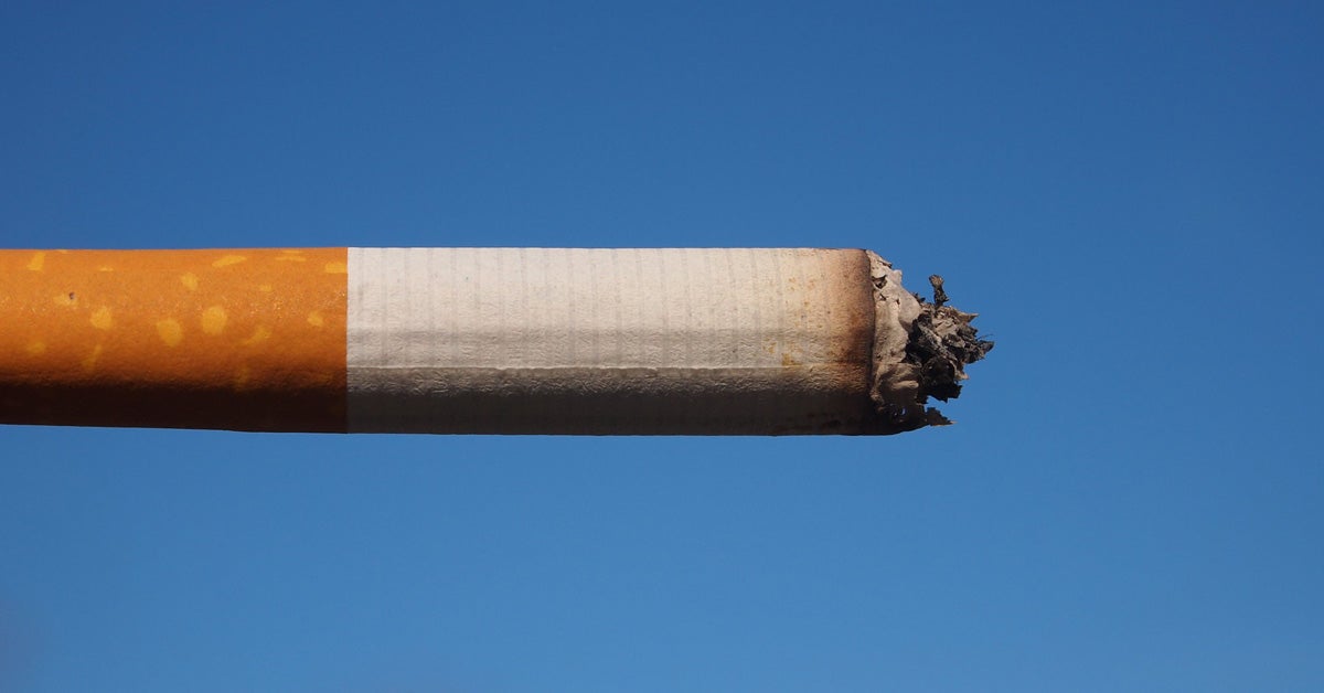 A partially used cigarette against a blue sky.