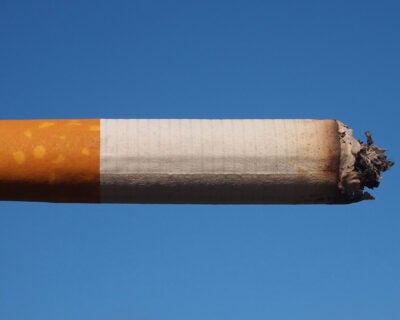 A partially used cigarette against a blue sky.
