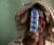 A male tuberculosis patient holds a strip of blue packaged medicines, covering the left part of his face, at a hospital in India.