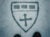 The Harvard Chan school crest is drawn in a layer of snow. A pair of snow boots peek into the frame.