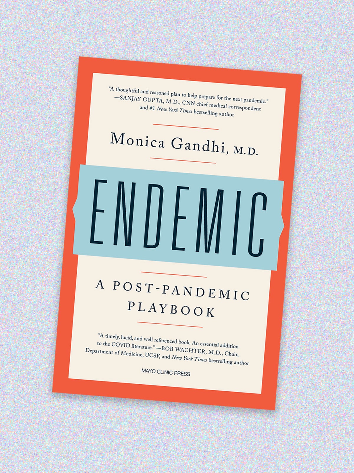 Book cover for “Endemic: A Post-Pandemic Playbook” by Monica Gandhi, M.D. The book cover has a light beige background, bright orange border and the word “ENDEMIC” in all caps in a light blue bar in the middle. Above the title is a quote and the author’s name, and below is the subtitle and another quote. The compassion is on a light purple speckled background.