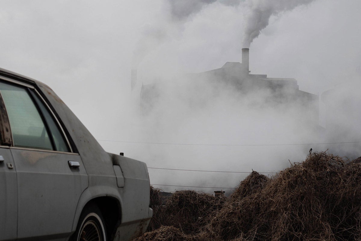 Smoke emissions from a steel plant in rural Pennsylvania. An old car is in the foreground, nearly out of frame.