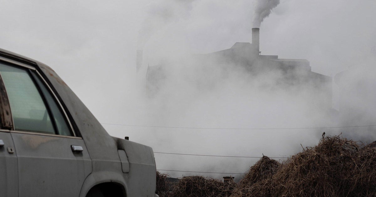 Smoke emissions from a steel plant in rural Pennsylvania. An old car is in the foreground, nearly out of frame.