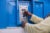 A woman uses a SHOFCO key to pay for her water at a metal kiosk.