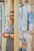 Deanna Adkins, stands in the door frame of a medical office hallway. She looks pensively at the camera.