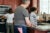 A family stands in their kitchen preparing a meal.