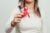 A woman, face out of view and body blurred, holds a condom with a red AIDS ribbon hanging off the corner.