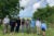 Eight professors and researchers wearing face masks stand at a research site in Puerto Rico.