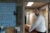 A middle-aged male funeral director looks at the camera while holding a hearse. He's in a doorframe in a basement. A wall of keys on a blue peg board are to his left.