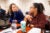 Lupe Washington and Alivia Langley sit at a table in a classroom in conversation.