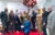 Ten graduates of the Community Violence Intervention Program pose for a group photo by a branded backdrop at a ceremony. They were suits and dresses.