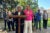 Gail LeBoeuf and Barbara Washington stand at a podium. New Orleans buildings and a large tree are visible in the background.