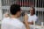 A young male canvasser speaks to a middle-aged man over a white fence in Puerto Rico.