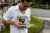 A young man wearing a white shirt and glasses, holds and organizes canvassing pamphlets on a neighborhood corner in Puerto Rico.