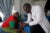 A male Kenyan doctor show a birth control packet to a female patient at a clinic in Nairobi.